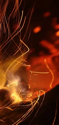 Looking for a stunning live wallpaper for your phone? Check out this amazing depiction of a close-up fire with sparks coming out of it! The picture captures the mesmerizing dance of flames in a figuration libre style, creating a mesmerizing display of warmth and light