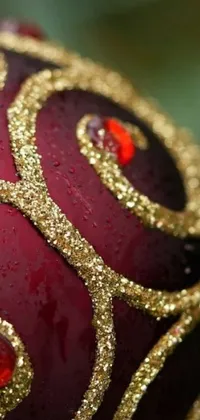 Decorate your phone with a stunning red and gold Christmas ornament live wallpaper featuring maroon metallic accents and glittery details