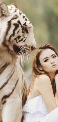 This stunning live wallpaper features a beautiful woman sitting next to a majestic white tiger