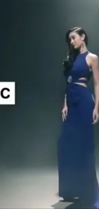 This is a dynamic live wallpaper featuring a woman in a flowing blue dress standing in a dimly-lit room