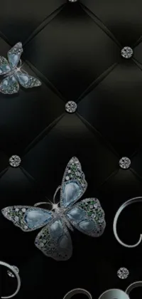 This stunning phone live wallpaper features a close-up of a cell phone adorned with vibrant butterflies and an abstract black leather background with diamond accents