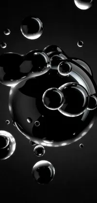 This live wallpaper features a black background with floating bubbles in digital art style