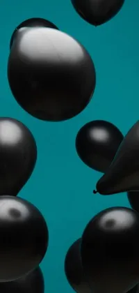 This phone live wallpaper features graceful black balloons floating on a vibrant teal studio backdrop