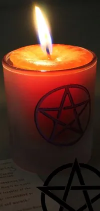 This mystical live wallpaper features a pentagram candle design with a red and orange glow for a cozy ambiance