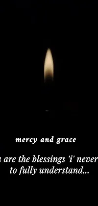 Immerse yourself in a serene ambiance, as you gaze upon a lit candle with the words mercy and grace etched on it