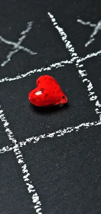 This phone live wallpaper showcases a powerful red heart on a blackboard background with stunning graffiti art