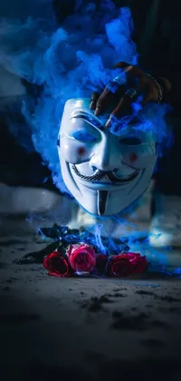 This phone live wallpaper features an enigmatic mask with smoke, roses, and a blue flame, creating a mesmerizing and mysterious atmosphere