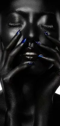 This phone live wallpaper features a mysterious woman with blue skin, covered by her hands and surrounded by shiny oil, smoke, and sparkling effects