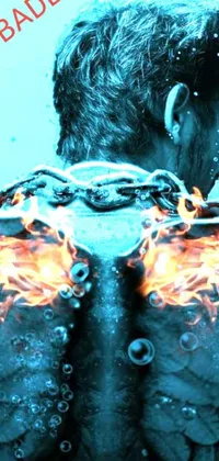 This phone live wallpaper depicts a man standing in water amidst fiery flames with glass wings