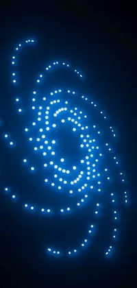 This phone live wallpaper features a stunning spiral of blue lights in the dark, rendered digitally with kinetic pointillism