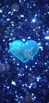 This phone wallpaper boasts a dazzling blue glitter heart on a black background that creates a mesmerizing visual effect