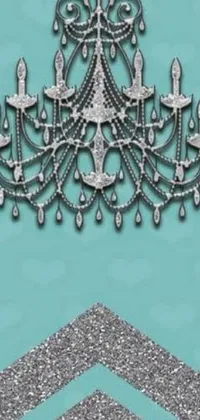 Looking for a wallpaper that exudes luxury and elegance for your phone? Check out this silver chandelier on a turquoise background designed by Jeka Kemp