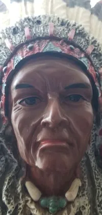 This close up live wallpaper showcases a detailed bronze statue of a person wearing a traditional headdress inspired by Native American heritage