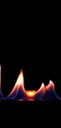 This mesmerizing phone live wallpaper display showcases a close-up view of a flickering fire against a black background
