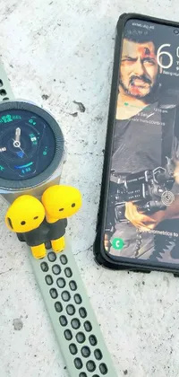 This live wallpaper depicts a smartwatch and smartphone on a yellow battlefield-themed surface