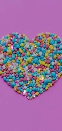 This live wallpaper features a colorful heart made of sprinkles on a pink background