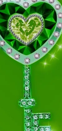 This phone wallpaper features a green heart-shaped key on a lush green backdrop with diamond and emerald gems accents