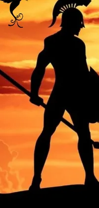 This live phone wallpaper showcases a formidable Spartan warrior standing atop a hill and holding a spear