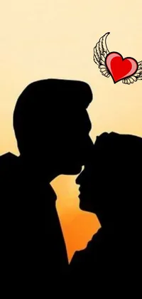 This live wallpaper features a romantic design with a heart in the center, surrounded by a wind-kissed picture of a couple kissing, casting a beautiful silhouette against the backdrop