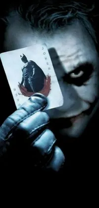 This live wallpaper features a close-up shot of a playing card, a promotional image from a famous movie featuring Batman as The Joker, and a unilalianism-inspired background design
