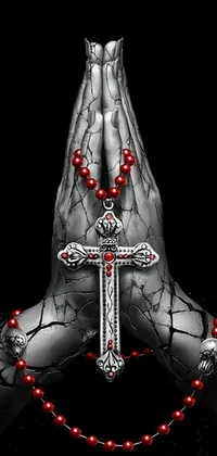 This Gothic-inspired live wallpaper features a detailed digital rendering of a cross held closely by a person's prayerful hands