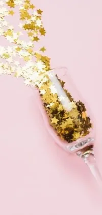 This live wallpaper showcases a sparkling glass of champagne with gold stars rising from it, set against a pink background with decorative elements including hearts, a ribbon, and a bow