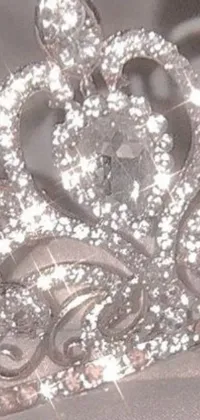 This phone live wallpaper features a stunning tiara set atop a white cloth