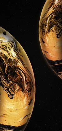 This live phone wallpaper showcases two planets rotating next to each other, enveloped in a vibrant blend of black and golden fluid