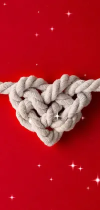 This phone live wallpaper features a stunning knot in the shape of a heart on a vibrant red background