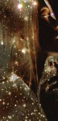 This phone live wallpaper features a close-up of a person wearing a hoodie amidst glittering stars, with gossamer gold dress and glowing mushrooms