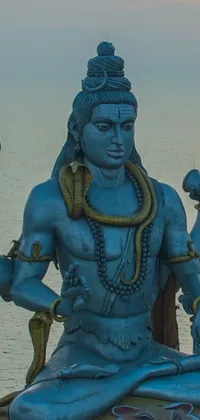 This beautiful live wallpaper for your phone features a stunning blue and black statue known as samikshavad, perched on top of a rocky outcropping overlooking the mesmerizing ocean