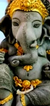 This phone live wallpaper features a stunning statue of an elephant holding a small baby elephant in its trunk