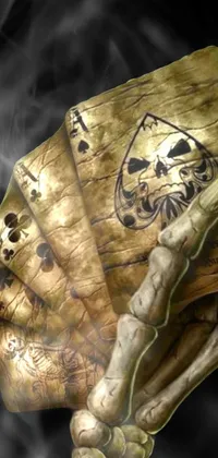 This skeleton hand live wallpaper for your phone features a detailed digital art rendering of a bony hand holding a traditional deck of playing cards