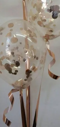 This phone live wallpaper features colorful balloons adorned with confetti dots on a rose gold background