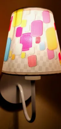 The phone live wallpaper depicts a candy land style abode with an eye-catching feature - a colorful lamp on a wall