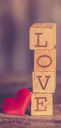 This phone live wallpaper showcases a wooden block with the word "love" written on it in an elegant font
