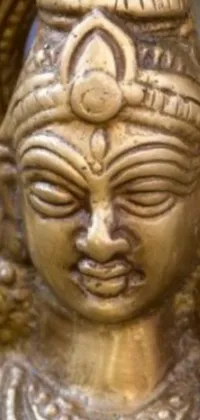 This phone live wallpaper showcases a striking figurative statue of a woman with traditional Indian elements such as a third-eye tika and a horned god