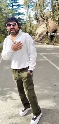 This phone live wallpaper features a rugged man standing on a sunny road with mountains in the background