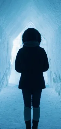This phone live wallpaper features an awe-inspiring image of a woman standing in a tunnel of snow