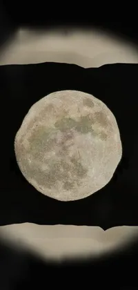 This phone live wallpaper showcases a breathtaking digital painting of a full moon casting its shimmering radiance through a hole in the sky