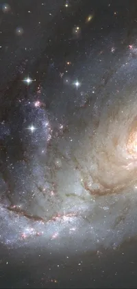 This phone live wallpaper is a stunning depiction of a spiral galaxy with a background of twinkling stars