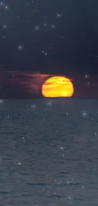 This live phone wallpaper showcases a breathtaking scene as the sun sets on a gorgeous body of water in Greece, while a crimson blood moon rises in the background