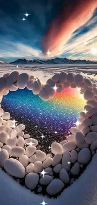 Enhance your phone with a unique live wallpaper- a heart-shaped rock arrangement amidst the snow! This vibrant image contains a rainbow-colored reflection along with a majestic nature background