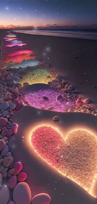This phone live wallpaper showcases a heart-shaped arrangement of rocks on a serene beach
