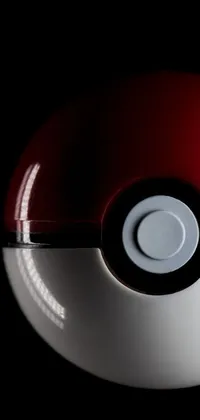This phone live wallpaper features a captivating image of a red and white poke ball placed on a sleek black surface