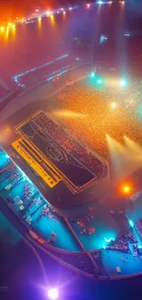 This phone live wallpaper showcases a captivating aerial view of a massive stadium gleaming with colorful lights and enveloped in a misty atmosphere