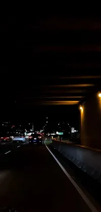 Get a beautiful live wallpaper for your phone with a car driving under a bridge at night