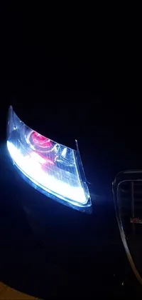 This live wallpaper for your phone depicts a striking close-up of a car's headlights at night