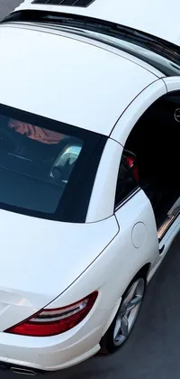 This phone live wallpaper features a stunning white Mercedes SLR parked with doors open in a lot