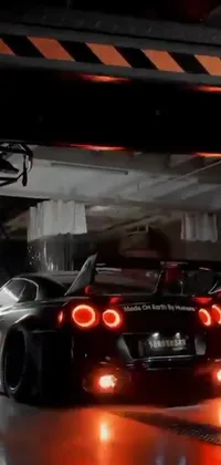 This black sports car live phone wallpaper showcases a parked Nissan GTR R 3 4 in a modern garage